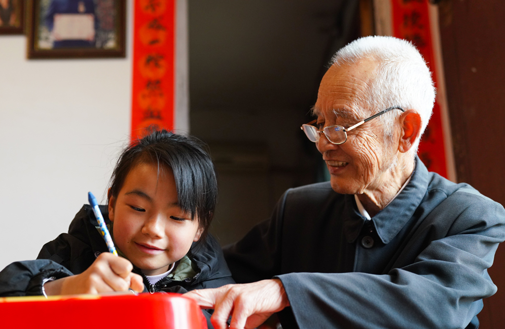 缪延相在校外辅导站指导学生完成作业(4月20日摄)。